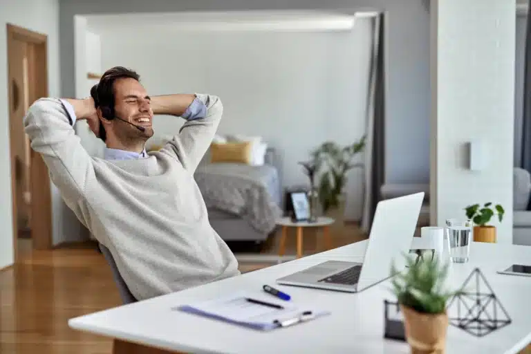 Homem em frente ao computador mostrando bem-estar no trabalho