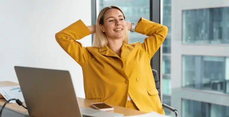 Mulher sorrindo, sentada na mesa