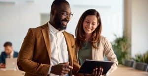 Business partner conversando com uma mulher, mostrando dados em um tablet